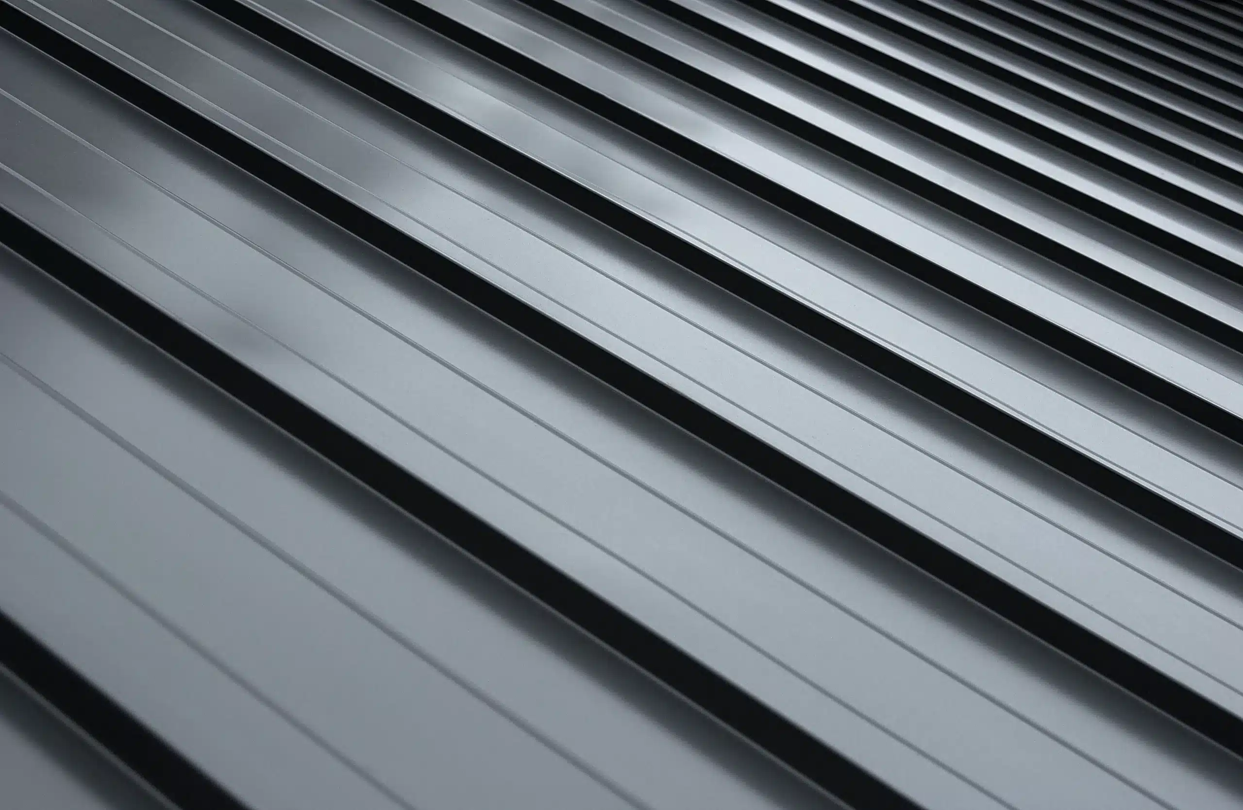 Close-up view of gray standing seam metal roofing panels showing the durability and modern design featured in residential metal roofs.