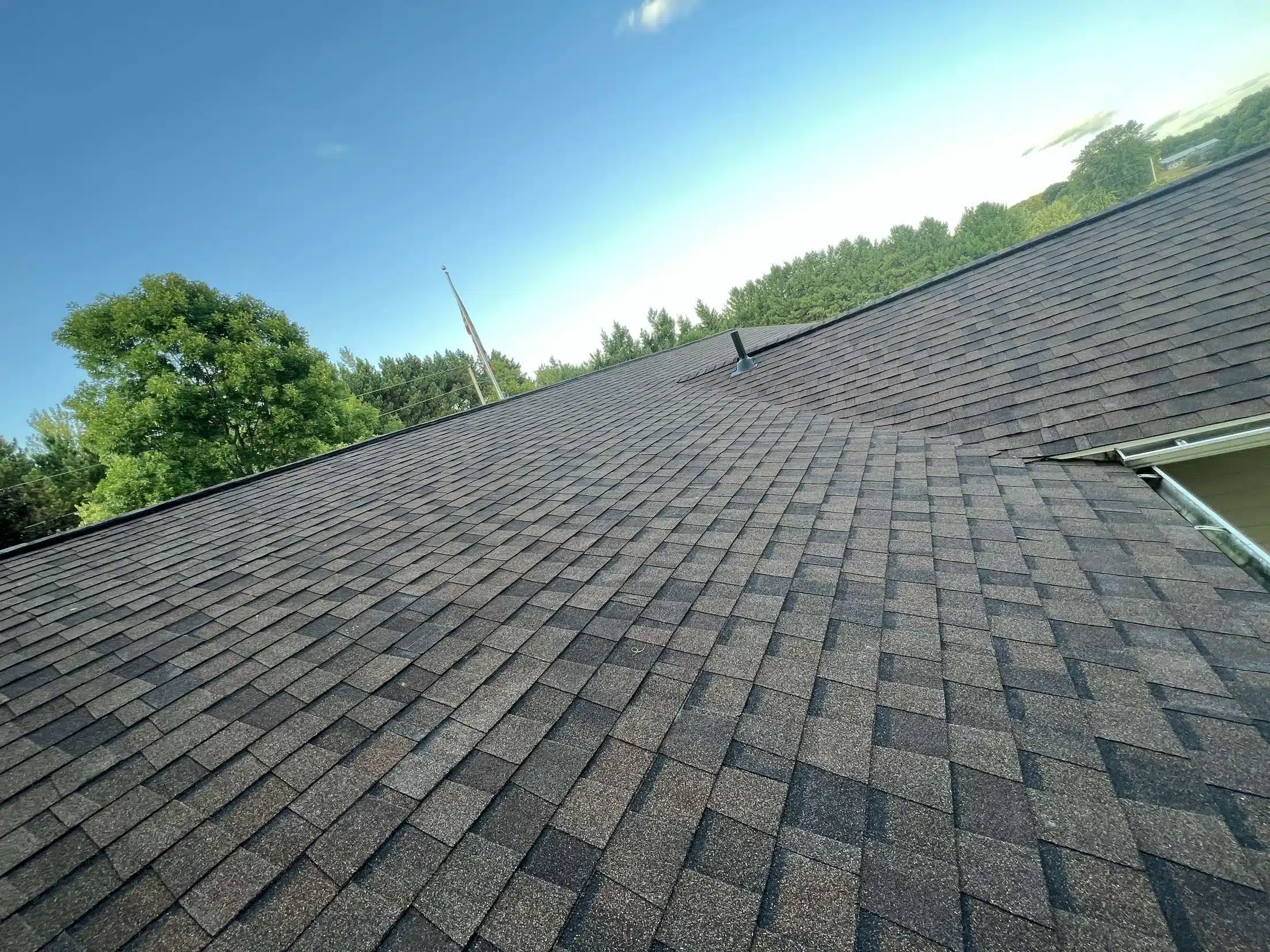 Asphalt shingle roof inspection showing vent flashing and even shingle wear